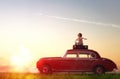 Girl sitting on roof of car.