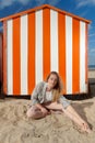 Girl sitting sun sand hut, De Panne, Belgium Royalty Free Stock Photo