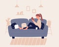 Girl sitting on sofa or couch with pillow ond read book. Young woman resting in cozy atmosphere of her room, apartment