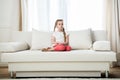 Girl sitting on sofa at home Royalty Free Stock Photo