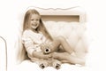 Girl sitting on sofa hugging teddy bear Royalty Free Stock Photo