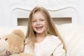 Girl sitting on sofa hugging teddy bear Royalty Free Stock Photo