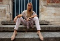 Girl sitting stairs medieval Romanesque door evening sun Royalty Free Stock Photo