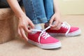 Girl Sitting On Stairs And Tying Shoelaces