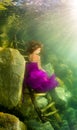 Girl sitting on the stairs under water