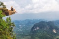 Girl sitting at the stone rock. Picturesque observation point