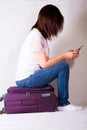 Girl is sitting on a suitcase Royalty Free Stock Photo