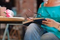 Girl sitting at summer terrace in street with morning coffee and reading book Royalty Free Stock Photo