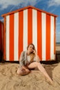 Girl sitting sun sand hut, De Panne, Belgium Royalty Free Stock Photo