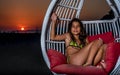 Girl sitting in the swing on the beach in the sunset Royalty Free Stock Photo