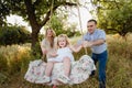 Girl sitting on a swing, father on mother pushing on nature,happy family, parents, smile, joy