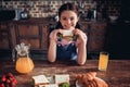 Girl sitting at the table with food for breakfast