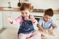 Boy and girl littered in flour in the kitchen