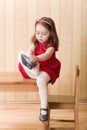 Girl sitting on table and put on one's shoes