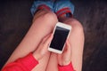 A girl is sitting on the toilet bowl with a phone in her hands, top view. Remote work from home due to quarantine and isolation Royalty Free Stock Photo