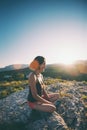 The girl is sitting on the top of the mountain at sunset. Royalty Free Stock Photo