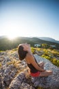 The girl is sitting on the top of the mountain at sunset. Royalty Free Stock Photo