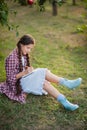 The girl sitting under the tree and wrote in Notepad