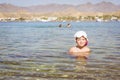 Girl sitting in water in middle of beach Royalty Free Stock Photo