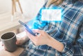 Girl is sitting on the white bed. Young woman is searching information in internet. Empty message window from smartphone screen. Royalty Free Stock Photo