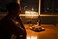A girl sitting by the window with the menorah celebrating Hanukkah. Royalty Free Stock Photo
