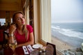 Girl sitting by the window with a ocean view Royalty Free Stock Photo