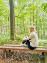 Girl sitting on an wooden bench in the forest in spa resort Marianske Lazne Royalty Free Stock Photo