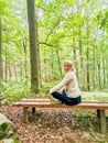 Girl sitting on an wooden bench in the forest in spa resort Marianske Lazne Royalty Free Stock Photo