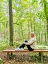 Girl sitting on an wooden bench in the forest in spa resort Marianske Lazne Royalty Free Stock Photo