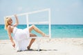 Girl sitting on wooden window on beach