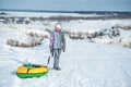 Girl in ski clothes drags tubing snow on the hill Royalty Free Stock Photo