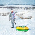 Girl in ski clothes drags tubing snow on the hill Royalty Free Stock Photo