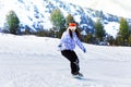 Girl in ski mask sliding with snowboard