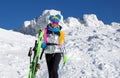 Girl skier enjoys the ski resort. Beautiful woman in winter outfit is posing with skis in the mountains. Winter sports. Skiing Royalty Free Stock Photo