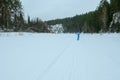 girl skiing with ski poles in a blue suit on a snowy river with rocks Royalty Free Stock Photo