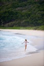 Girl skipping along the shore,seychelles.
