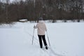 Girl on skis in the winter forest. Snow and ice on the branches of trees. Tourist recreation