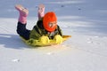 Girl Sledding on Snow Covered Lake