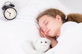 The girl is sleeping with an alarm clock, hugging Royalty Free Stock Photo