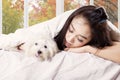 Girl sleeping on the bed with her puppy Royalty Free Stock Photo