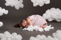 Girl sleeping on a cloud, shot in the studio on a gray background