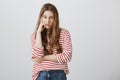 Girl almost sleeps from boredom during class. Portrait of indifferent tired female model supporting head with hand Royalty Free Stock Photo