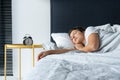 The girl sleeps next to the alarm clock. Time to wake up. On the wake-up clock 7 a.m. Deep sleep Royalty Free Stock Photo