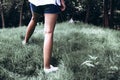 Girl with slender tanned legs walking in the park on the green grass Royalty Free Stock Photo