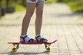 Girl slim legs in white socks and black sandals standing on pave