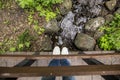 Girl in slippers and jeans standing on a wooden bridge, which is Royalty Free Stock Photo