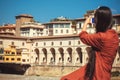 Girl with smartphone making picture of river Arno near famous bridge of Florence, ancient Tuscany city in Italy