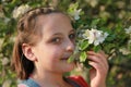 Girl smelling the blossoms of an apple tree Royalty Free Stock Photo