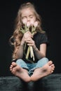 Girl smelling tulips bouquet on black Royalty Free Stock Photo