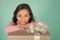 Girl smile with gift box, ribbon bow on blue background Royalty Free Stock Photo